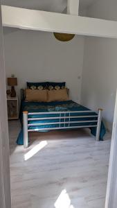 une chambre avec un lit dans une pièce blanche dans l'établissement Appartement cosy 4 pers Drancy, à Drancy