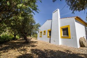 ein kleines weißes Gebäude mit gelben Fenstern in der Unterkunft Herdade do Gamito in Crato