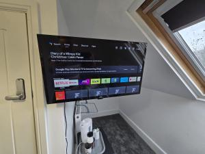 a flat screen tv hanging on a wall at DDR House in Nelson
