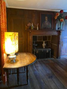 a room with a table with a lamp and a fireplace at Chambre avec du charme in Saint-Martin-sous-Vigouroux +4 photos