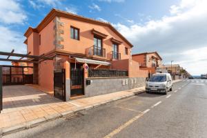 un coche aparcado frente a un edificio en una calle en Casa Las Brisas Fuerteventura, en Puerto del Rosario
