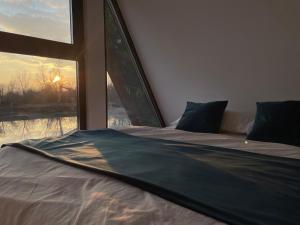 a bed in a room with a large window at LaKadisa pe Lac in Porumbacu de Jos