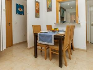 a dining room with a table with chairs and a mirror at Apartment Jardines del Mar I-1 by Interhome in El Borseral