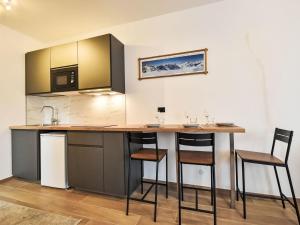 a kitchen with a counter and stools in a room at Studio San Anton by Interhome in Bormio +25 photos