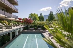 ナトゥルノにあるFeldhof DolceVita Resortの建物の横にあるプール
