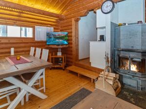 a dining room with a fireplace in a log cabin at Holiday Home Lakka by Interhome in Salla