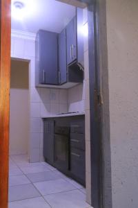 a kitchen with purple cabinets and a stove at Zone 4 Motel in Polokwane