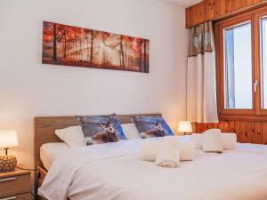 two beds in a bedroom with white sheets at Apartment Chaedoz 36 by Interhome in Nendaz