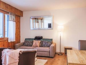 a living room with a couch and a mirror at Apartment Chaedoz 36 by Interhome in Nendaz