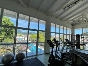 a gym with cardio equipment and a view of a pool at Casa em Maresias in São Sebastião