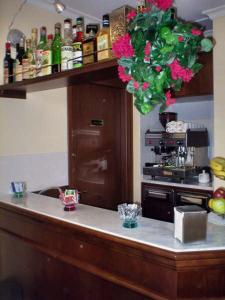 una cocina con encimera con botellas y flores en Soggiorno Angelus, en Roma