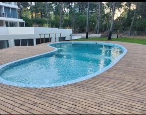 a large swimming pool on a wooden deck at Zeus II Pinamar in Pinamar