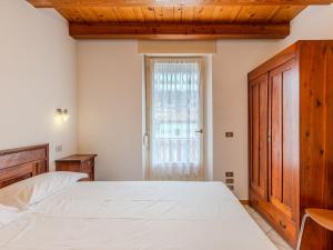 een slaapkamer met een groot bed en een raam bij Apartment Vento Alpino-1 by Interhome in Predaia +14 foto's