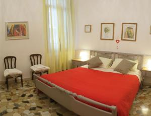 ヴェネツィアにあるApartment Minuettoのベッドルーム1室(赤い大型ベッド1台、椅子2脚付)