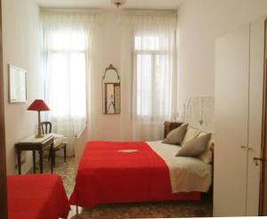 a bedroom with a bed with a red blanket at Apartment Minuetto in Venice