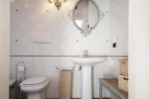 uma casa de banho com um WC, um lavatório e um espelho. em Zaffiro Bianco em San Gimignano