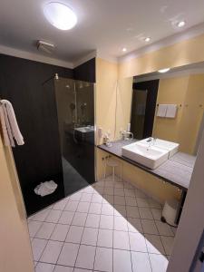 a bathroom with a sink and a shower at Parkhotel Green Garden in Bad Hersfeld