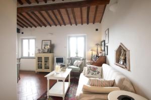 uma sala de estar com um sofá e uma mesa em Zaffiro Bianco em San Gimignano