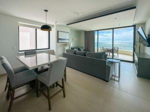 a living room with a couch and a table with chairs at Paradise Found Luxe 2BR Condo in Iconic Location in Puerto Peñasco