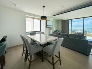 a living room with a table and chairs and a couch at Paradise Found Luxe 2BR Condo in Iconic Location in Puerto Peñasco +109 photos