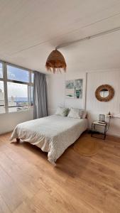 a bedroom with a large bed and a large window at Sunset View in Arona