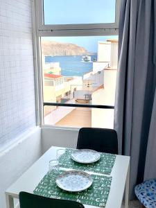 a table with two plates on it with a window at Sunset View in Arona