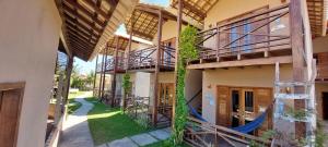 an apartment building with a hammock in the courtyard at Mar Doce Lar - Praia Macapa in Luis Correia