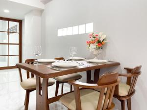 a dining room table with chairs and a vase of flowers at Lilly house near Krabi Airport with Free Airport Shuttle in Krabi town +17 photos