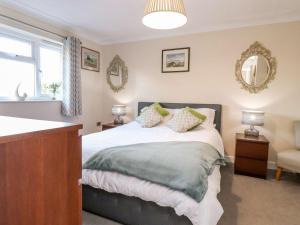ein Schlafzimmer mit einem Bett, einem Fenster und einem Spiegel in der Unterkunft Arnside House in Carnforth