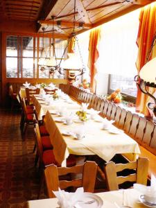 une salle à manger avec de longues tables et chaises dans l'établissement Hotel Igel, à Püchersreuth