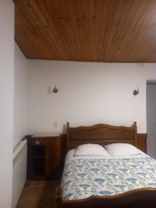 a bedroom with a bed and a wooden ceiling at Appartement St Jacques in Saint-Gervais-sur-Mare +1 photo
