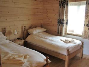 a bedroom with two beds and a window at Woodpecker Lodge in Market Rasen