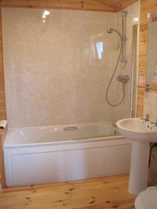 a bathroom with a bath tub and a sink at Woodpecker Lodge in Market Rasen