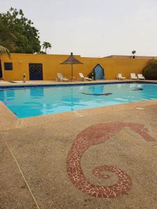 a swimming pool with a number on the ground at Maison 2 chambres dans résidence in Saly Portudal