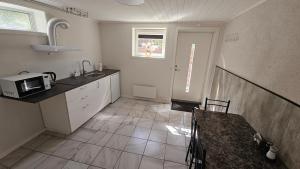 a kitchen with a sink and a microwave at Apartment in Rauma in Veblungsnes