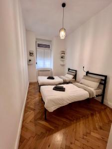 3 camas en una habitación con suelo de madera en Panta Rei home, en Trieste
