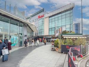 a group of people walking in front of a shopping mall at Premier Suites Shepherds Bush Westfields Penthouse Apartment in London
