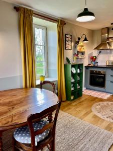 eine Küche mit einem Holztisch in einem Zimmer in der Unterkunft La Petite Bruyere Characterful 2 bedroom cottage with fireplace in Ambrières-le-Grand