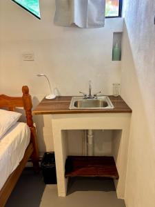 a bathroom with a sink next to a bed at Stella Mar Oceanfront Hotel in Popoyo