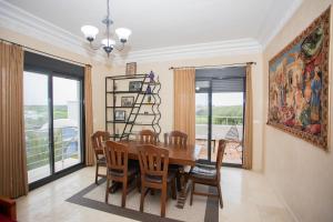 Un comedor con mesa y sillas de madera. en Apartamento en Residencia Jardines de Asilah, en Asilah
