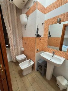 łazienka z umywalką, toaletą i lustrem w obiekcie Home To Fly w mieście Neapol
