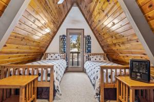 two beds in a attic room with wooden ceilings at Mescalero Flagstaff in Munds Park