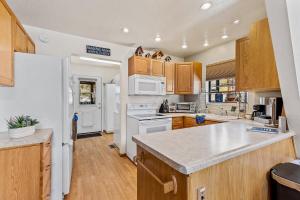 a kitchen with white appliances and wooden cabinets at Mescalero Flagstaff in Munds Park