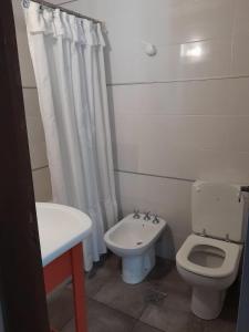 a white bathroom with a toilet and a sink at Depto 2 amb zona centro con cochera Solo familias in Mar del Plata +8 photos