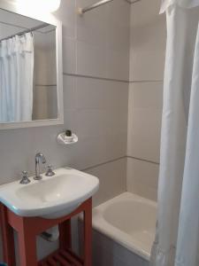 a white bathroom with a sink and a bath tub at Depto 2 amb zona centro con cochera Solo familias in Mar del Plata