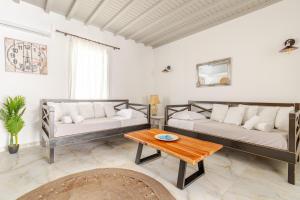a living room with two couches and a table at Elenitas beach house in Ornos in Ornos