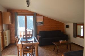 una sala de estar con un sofá y una mesa en La Loulettaz, en Le Grand-Bornand