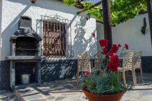 a patio with a table and chairs and a fireplace at Casa Número 3 in Válor