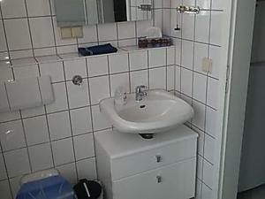 un bagno bianco con lavandino e specchio di Fewo Fam Große a Friedland