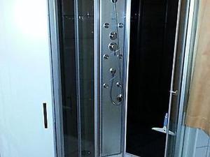 una porta doccia in vetro con maniglie metalliche di Fewo Fam Große a Friedland
